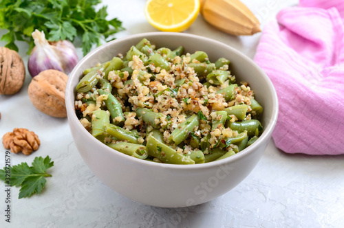 Salad with green beans and spicy walnut sauce in a bowl. Vegetarian, vegan menu
