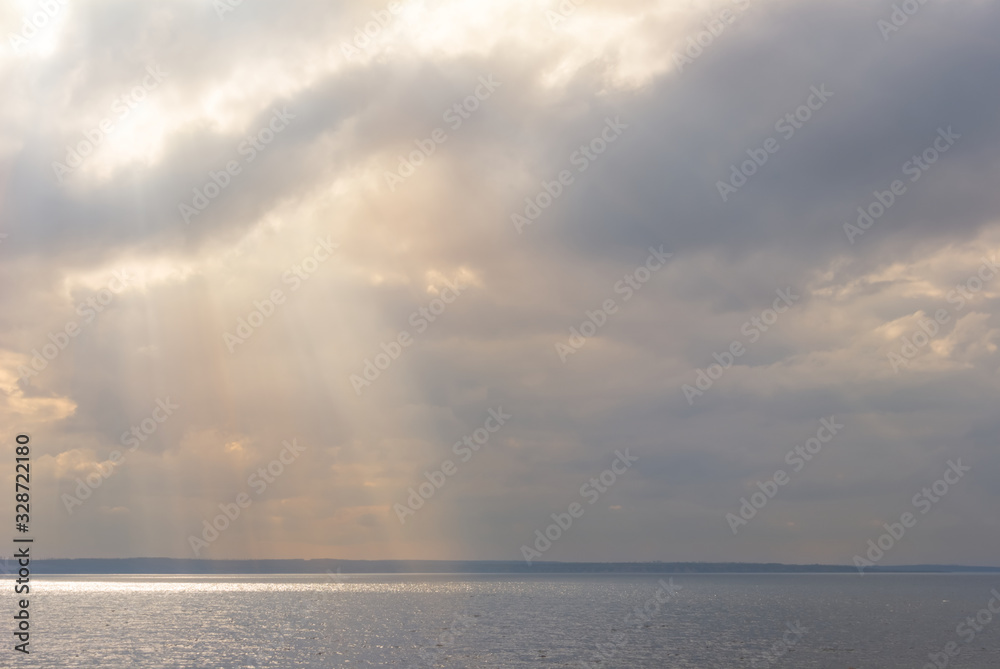 sun push through dense clouds above a sea bay
