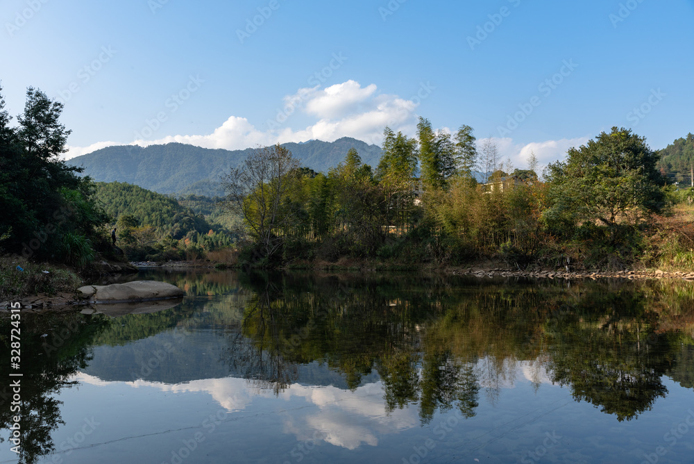 Under the blue sky, the rural lake reflects the landscape Under the blue sky, the rural lake reflects the landscape