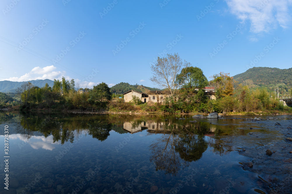 Fototapeta premium Under the blue sky, the rural lake reflects the landscape
