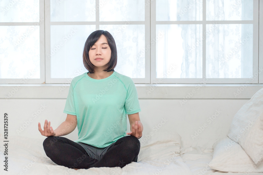 Portrait of calm Asian girl meditation in the morning. Young woman indoors Living lifestyle at home. Portrait of calm Asian girl meditation in the morning. Young woman indoors Living lifestyle at home.