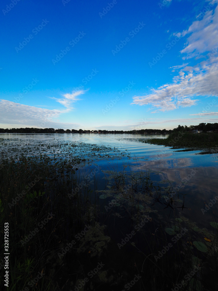 Lake with blue skies and clouds reflected Lake with blue skies and clouds reflected