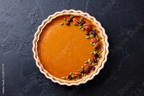 Obraz na płótnie Pumpkin pie in baking dish. Dark background. Close up. Top view.