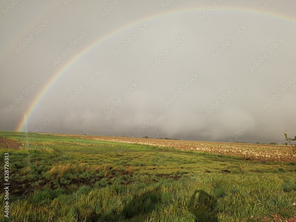 arcoiris en cielo nuboso sobre campo arcoiris en cielo nuboso sobre campo