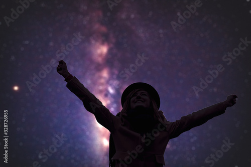 Woman enjoying starry night with arms wide open.