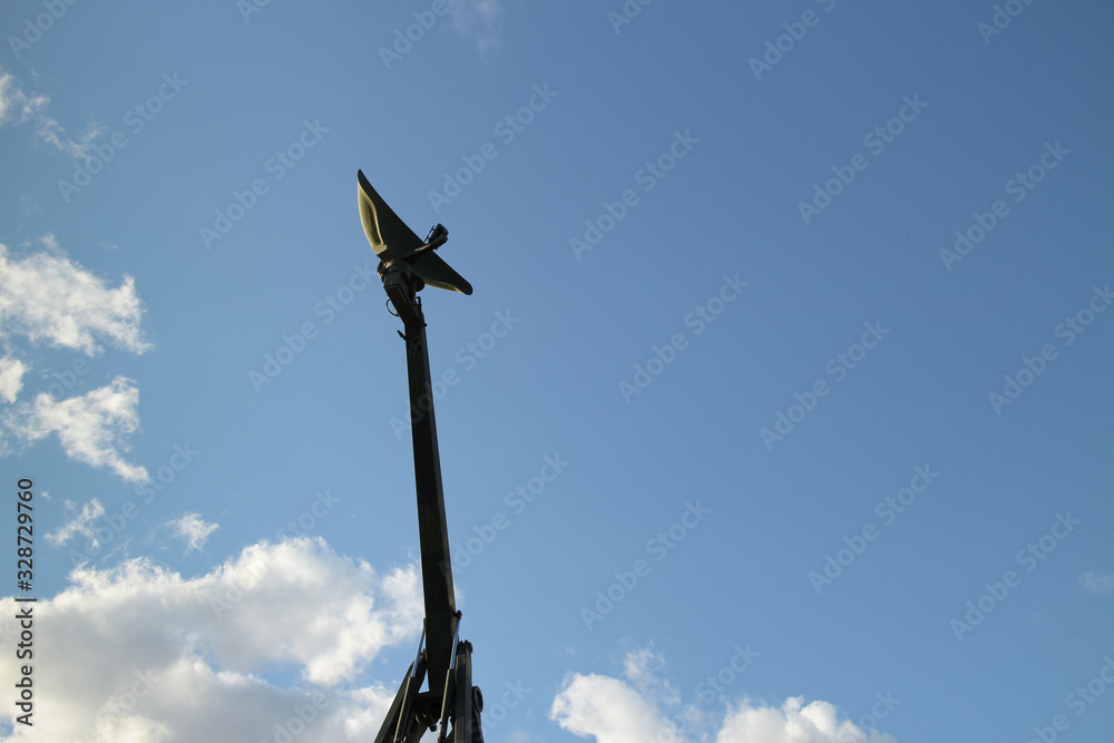 NATO military radar mobile complex installed on army communication vehicle against the sky with clouds background, copy space for text NATO military radar mobile complex installed on army communication vehicle against the sky with clouds background, copy space for text