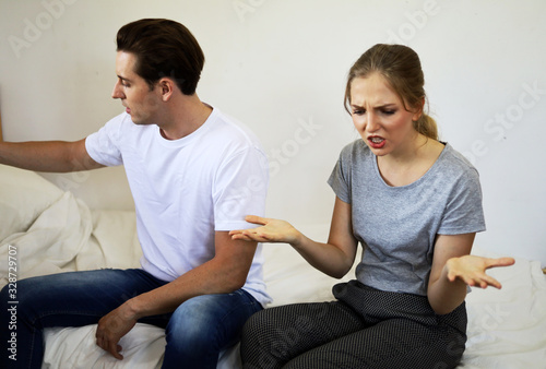 Young lovers sit sadly in the bedroom and bored with love problems.