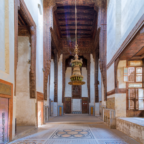 Hall at ottoman era historic house of Zeinab Khatoun with painted wooden ceiling, marble floor decorated with colorful geometric patterns, and big chandelier, Medieval Cairo, Egypt photo