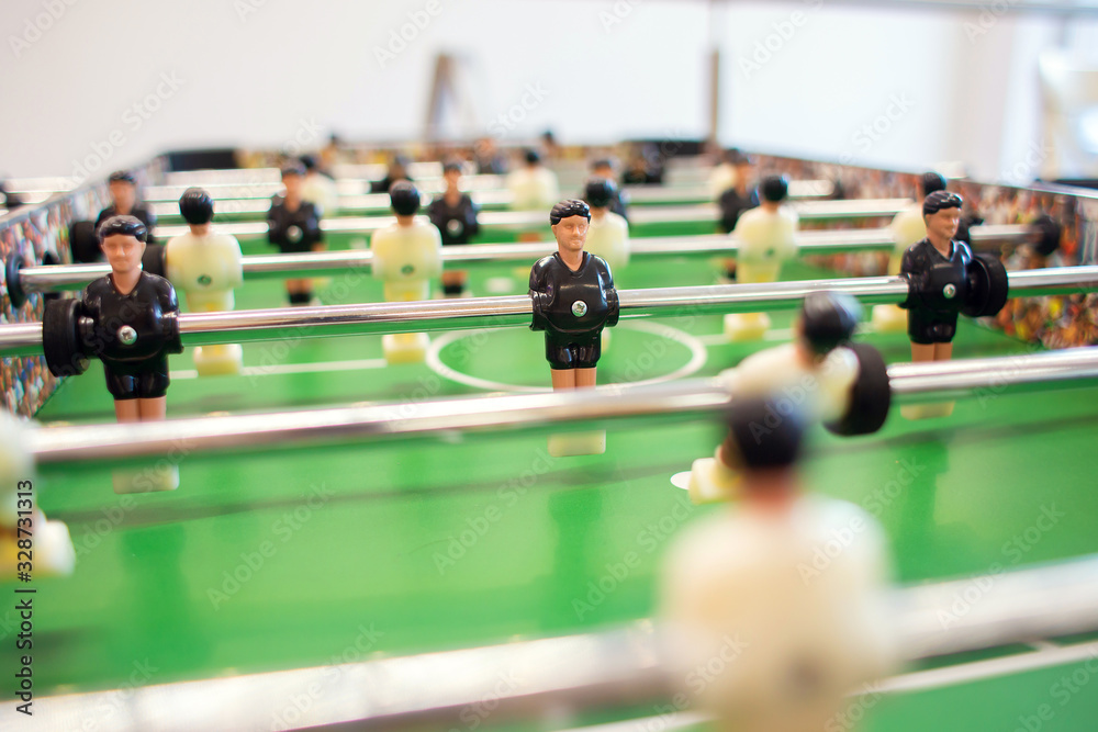 Big game table football in a bright room. Figures of soccer players close-up Big game table football in a bright room. Figures of soccer players close-up