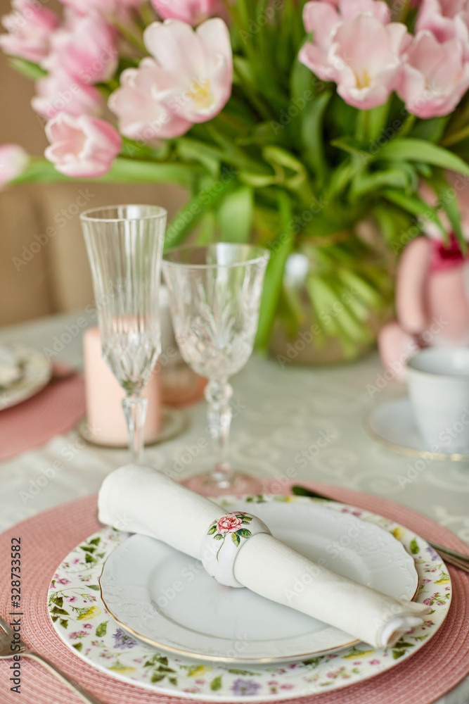 Decor and spring table setting is a vase with pink tulips Decor and spring table setting is a vase with pink tulips