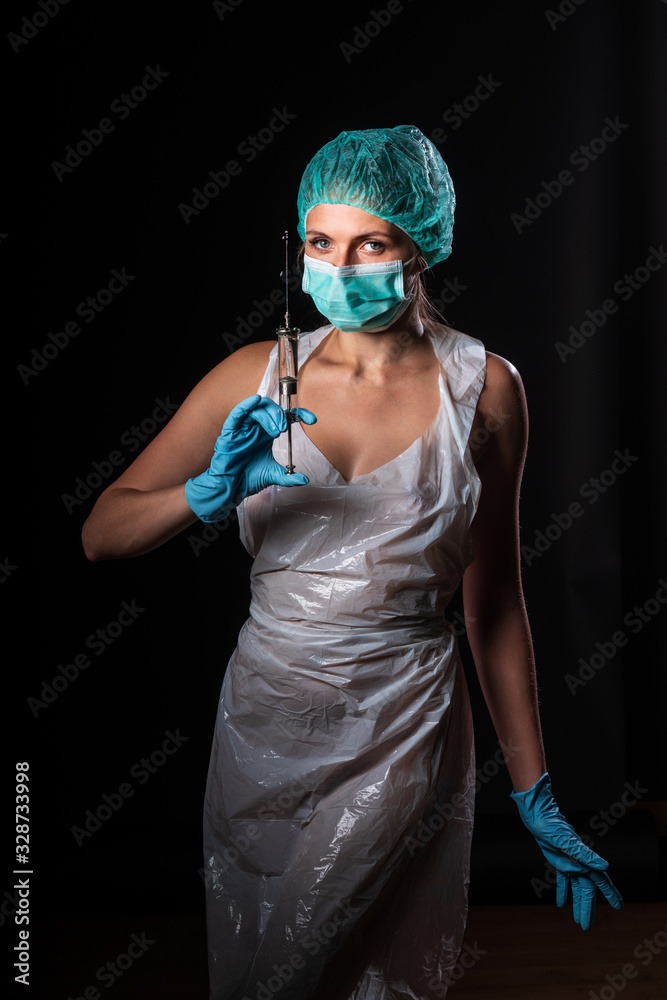 Sexy doctor in medical mask make protective injection. Naked nurse prepares  syringe. Medic in disposable medical clothing. preparing vaccination  against for a pandemic and flu season. Photos