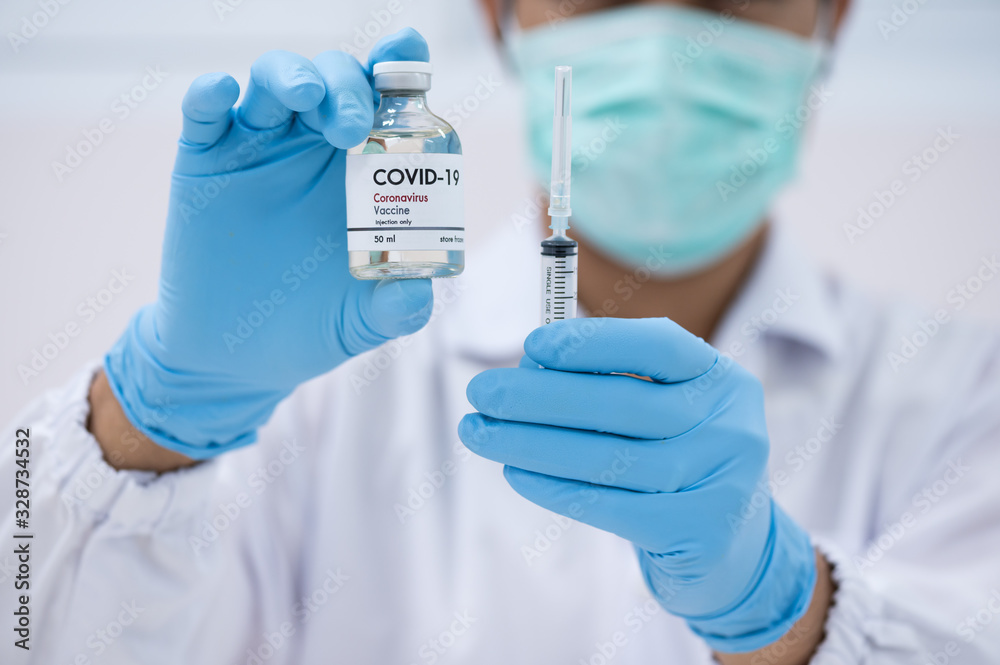 Doctor's hand holding syringe and bottle for vaccine to patient on white background.Vaccination against quarantine or covid-19.Protection against virus and infection control. Doctor's hand holding syringe and bottle for vaccine to patient on white background.Vaccination against quarantine or covid-19.Protection against virus and infection control.