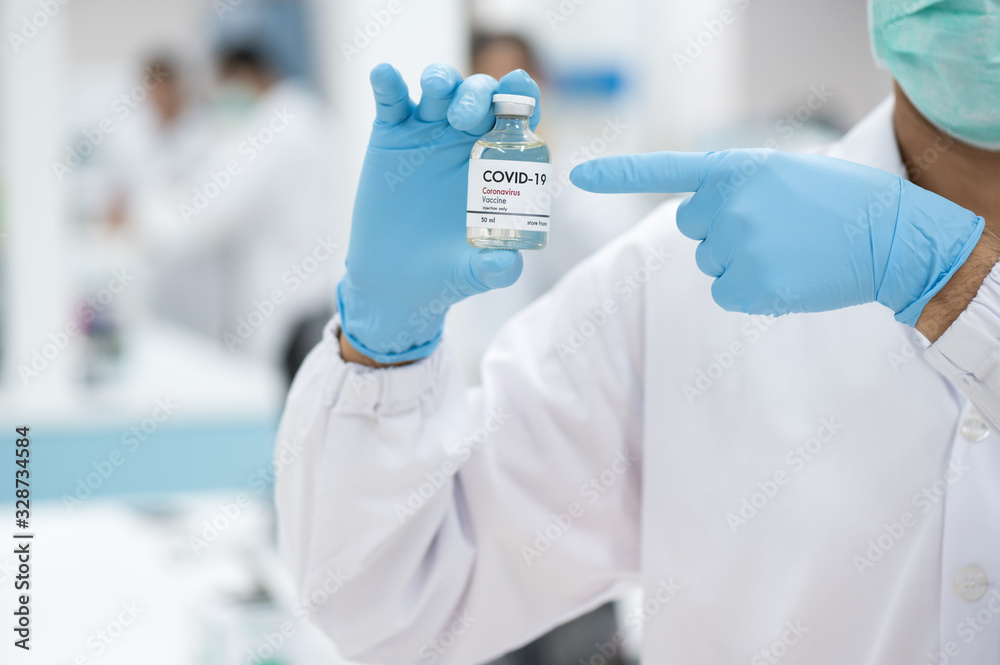 Fototapeta premium Doctor's hand holding bottle vaccine to patient in the hospital.Vaccination against coronavirus quarantine or covid-19.Protection against virus and infection control.Medication treatment concept.