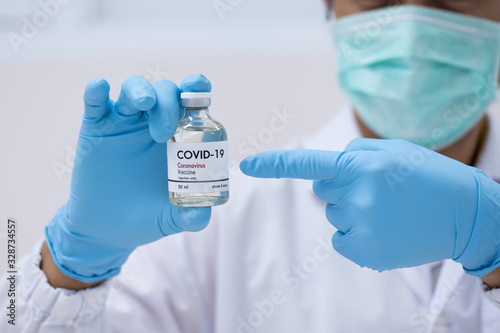 Doctor's hand holding bottle vaccine to patient in the hospital.Vaccination against coronavirus quarantine or covid-19.Protection against virus and infection control.Medication treatment concept.