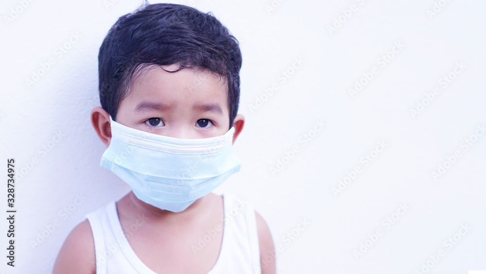 Portrait of cute little Asian 2 -3 years old toddler baby boy so sad face. Child wearing protective medical mask. Virus or PM 2.5 concept. 