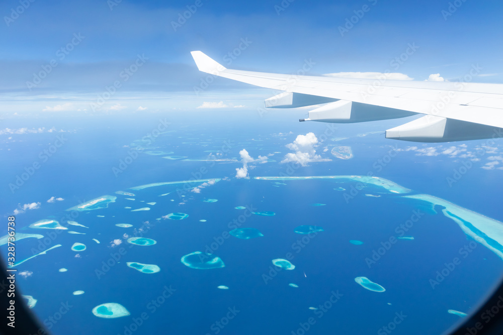 Top view of Maldive islands from airplane window with airplane's wing. Top view of Maldive islands from airplane window with airplane's wing.