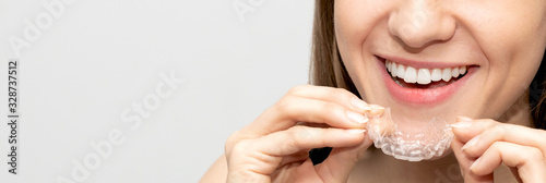 Young woman holding invisible aligner