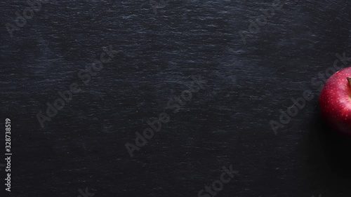 Stop motion animation of a dancing apple on slate background