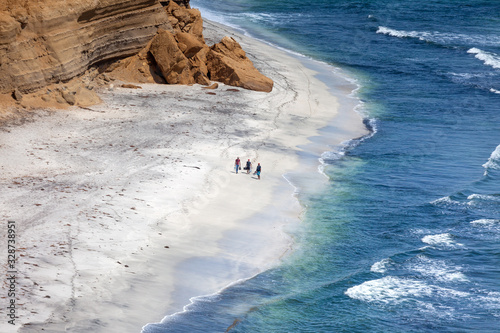 Three people walk along the ocean coast, Paracas, National Park, Peru 2019-12-05.