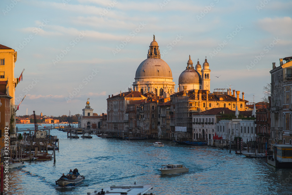 View of the Grand Canal in Venice during sunset. Ttraditional gondolas and boats with passengers.