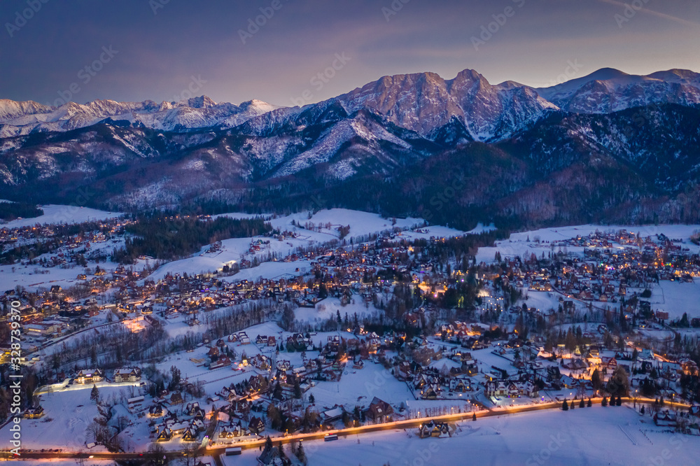Stunning illuminated Zakopane city after dusk in winter, aerial view