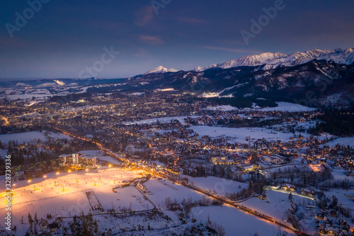 Breathtaking illuminated Zakopane city after dusk in winter, aerial view