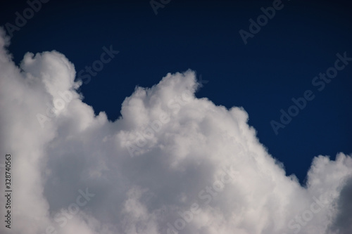 Large white cumulus clouds against a blue sky.