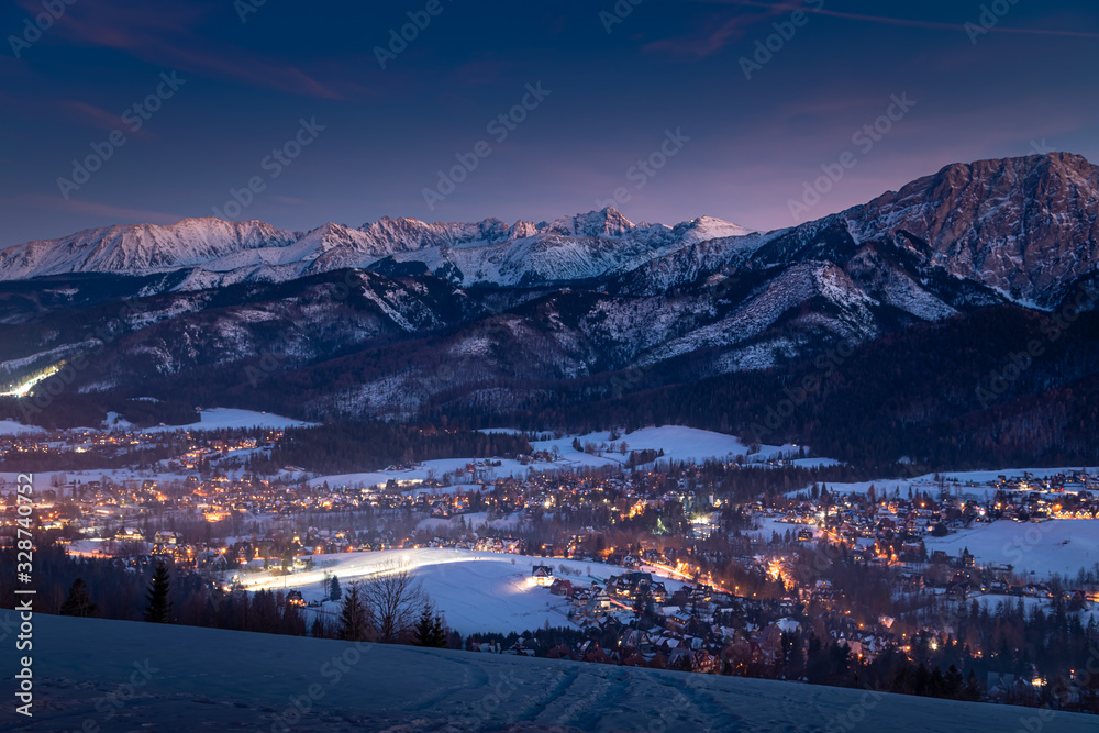 Amazing illuminated Zakopane city after dusk in winter, aerial view