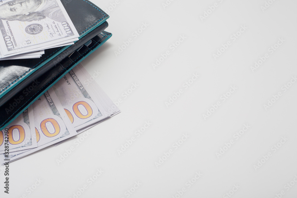 Dollars and a black leather wallet, on a white background, with space for text, with copy space. Concept backgrounds for financial topics, savings and salary. Dollars and a black leather wallet, on a white background, with space for text, with copy space. Concept backgrounds for financial topics, savings and salary.