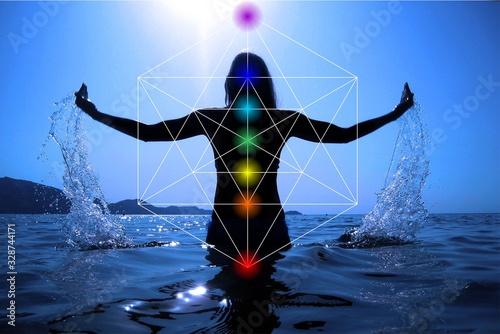 Celebrating life - Beautiful woman on the beach at sunset celebrating life with Sacred geometry Metatron's cube and 7 chakras photo
