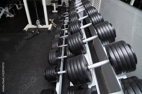 Black dumbbells for fitness classes in the gym.