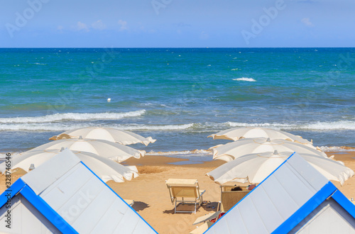 Typical sandy beach of Apulia. Gusmay beach, framed by two spectacular roky peaks, is surrounded by the Mediterranean scrub which reflects in the green water of the sea, (Italy). photo