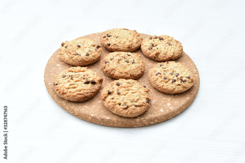 Oatmeal cookies and chocolate chips on light background Oatmeal cookies and chocolate chips on light background