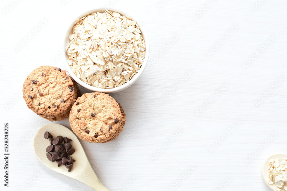 Oatmeal cookies and chocolate chips on light background Oatmeal cookies and chocolate chips on light background