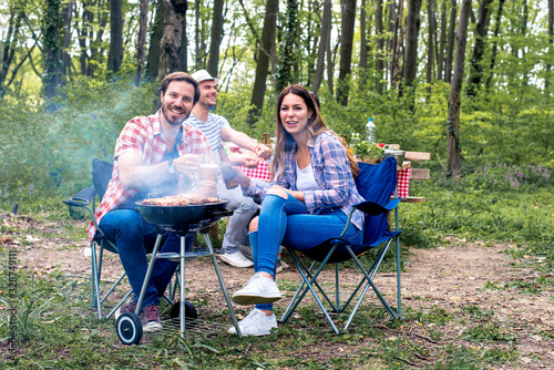 Couples spending time together in nature and making barbecue