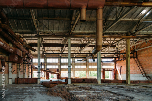 Old abandoned industrial building with rusty remnants of pipeline © Mulderphoto