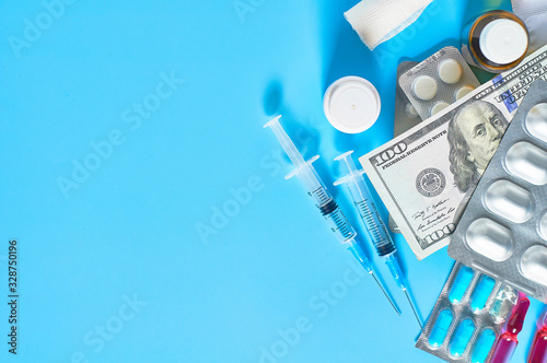 Different medicaments and money on blue background. Medical concept. Doctor salary. Corruption in healthcare.  Purchase of drugs. Health insurance. Virus vaccine manufacturing cost
