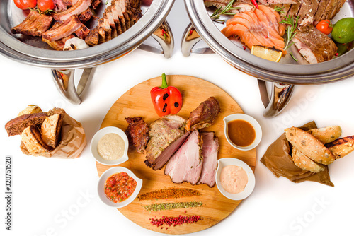 Assorted meat with vegetables and sauce on a white background