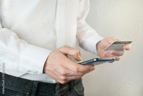 Businessman works with a smartphone and a bank card. Close-up of the hands of a working man. Money transfer. Brainstorm. Business goals.