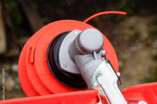 Head with fishing line for mowing grass. Gas trimmer. Trimer gascosis with a leaf for mowing grass and shrubs. photo