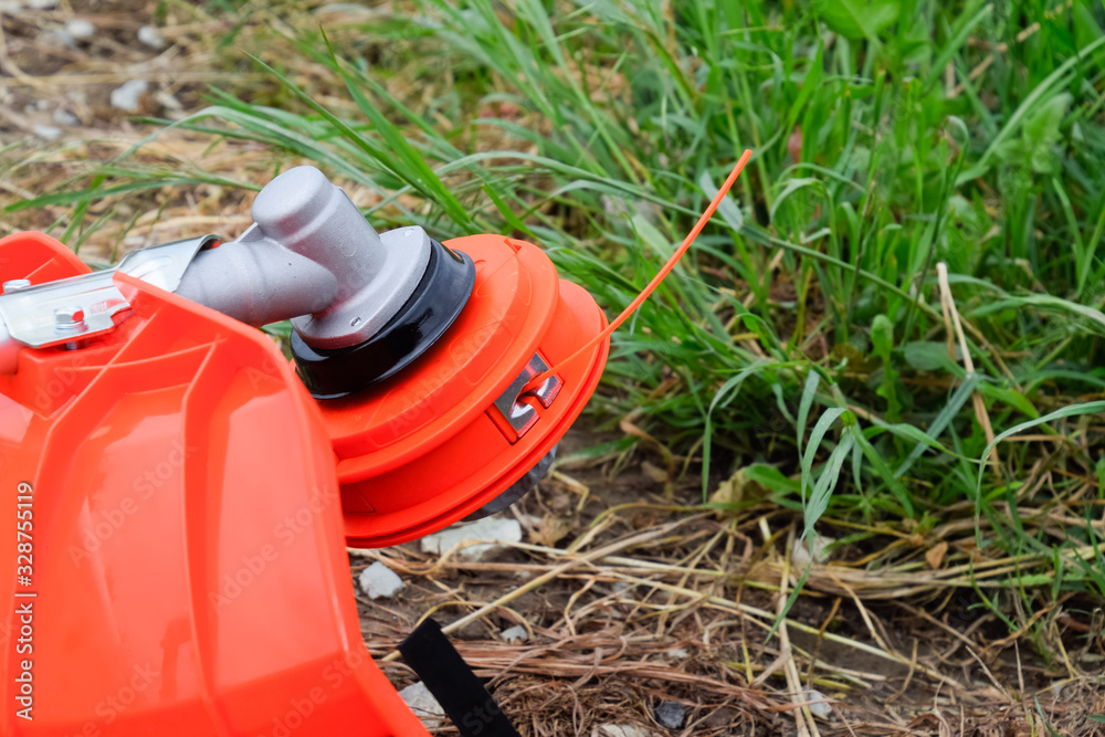 Head with fishing line for mowing grass. Gas trimmer. Trimer gascosis with a leaf for mowing grass and shrubs. Head with fishing line for mowing grass. Gas trimmer. Trimer gascosis with a leaf for mowing grass and shrubs.