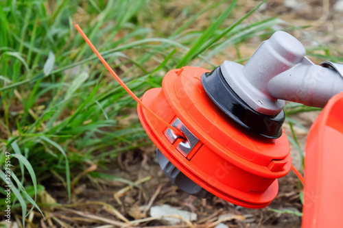 Head with fishing line for mowing grass. Gas trimmer. Trimer gascosis with a leaf for mowing grass and shrubs. photo