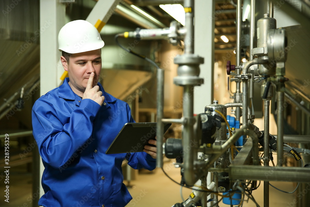 food factory worker is holding a tablet and thinking at plant near the equipment food factory worker is holding a tablet and thinking at plant near the equipment