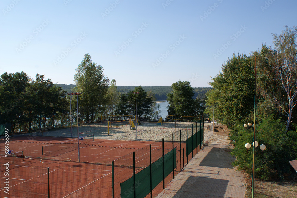 Tennis court and volleyball court in nature.