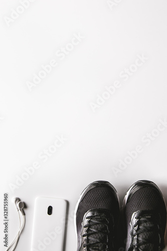 Mockup mobile cellphone with earphone and running shoes on white background. Healthy lifestyles