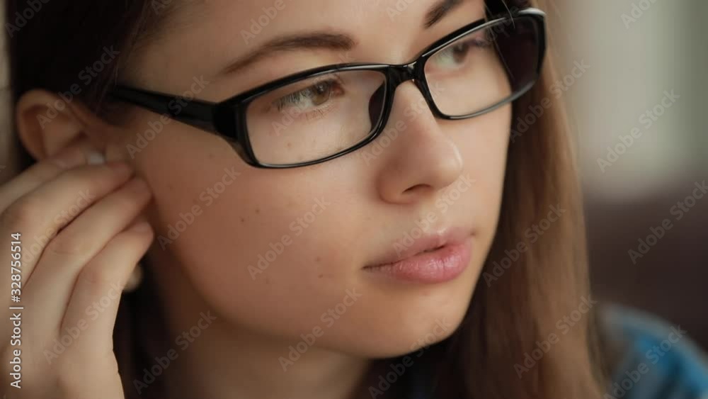 Closeup woman puts on wireless earbuds in her ear listening to music in earphones Closeup woman puts on wireless earbuds in her ear listening to music in earphones