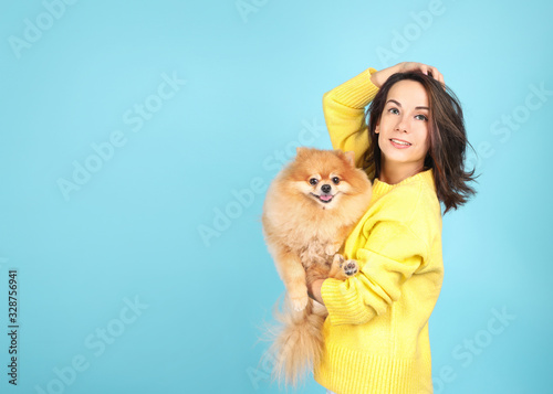 Fotografie Young woman with  dog on  blue background