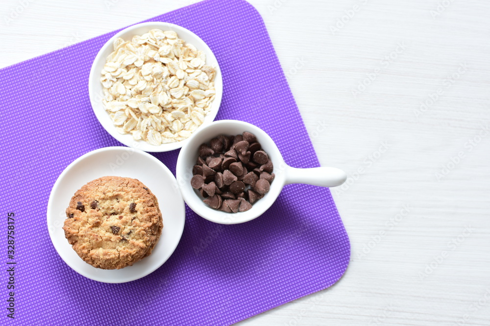 Oatmeal cookies and chocolate chips on colorful background Oatmeal cookies and chocolate chips on colorful background