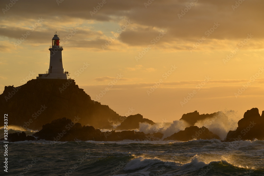 La Corbiere lighthouse, Jersey, U.K. Coastal structure at sunset.