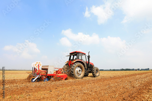 Farmers drive farm machinery to plant corn on the farm  Luannan County  Hebei Province  China.
